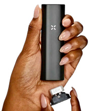 Load image into Gallery viewer, A PAX Plus Vaporizer in a person&#39;s hand with the chamber open.
