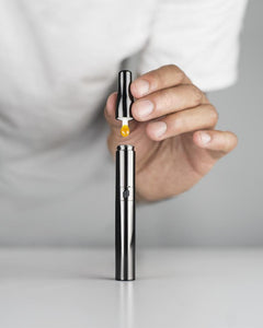 A Puffco Plus Black electronic dab vaporizer pen in use.